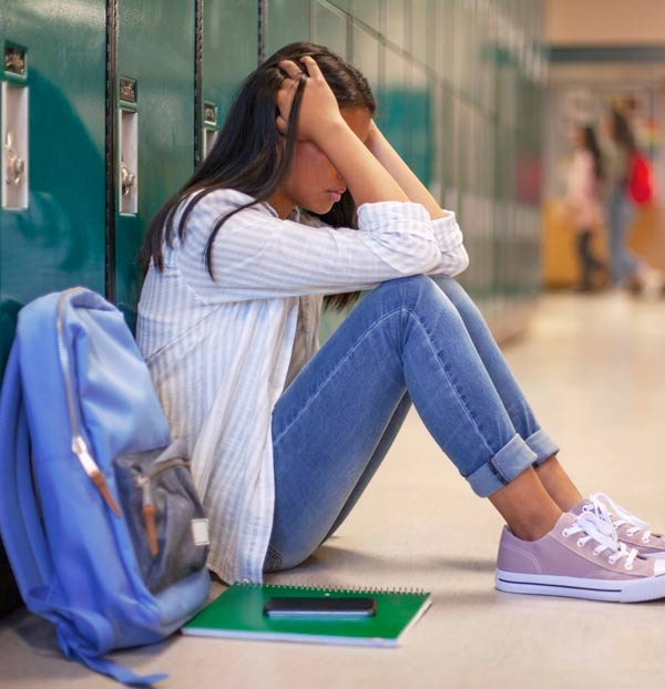 a stressed girl sitting down in a school